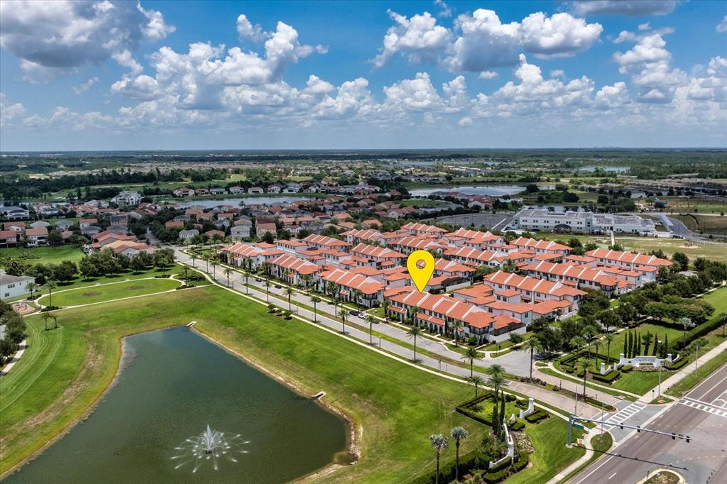 An aerial view of a residential community featuring townhomes with red tile roofs and ponds — 8937 LAKESHORE POINTE DRIVE, WINTER GARDEN, FL
