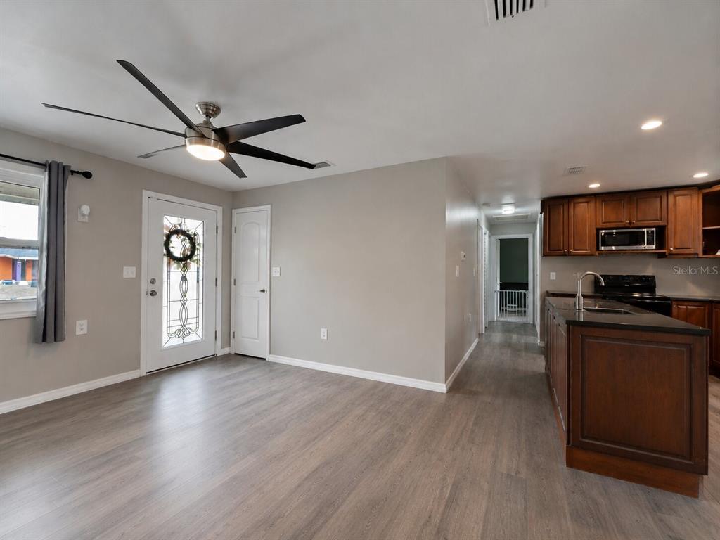 A kitchen with dark wood cabinets and a center island opens to a living area — 53 HIGHRIDGE ROAD, DAYTONA BEACH, FL