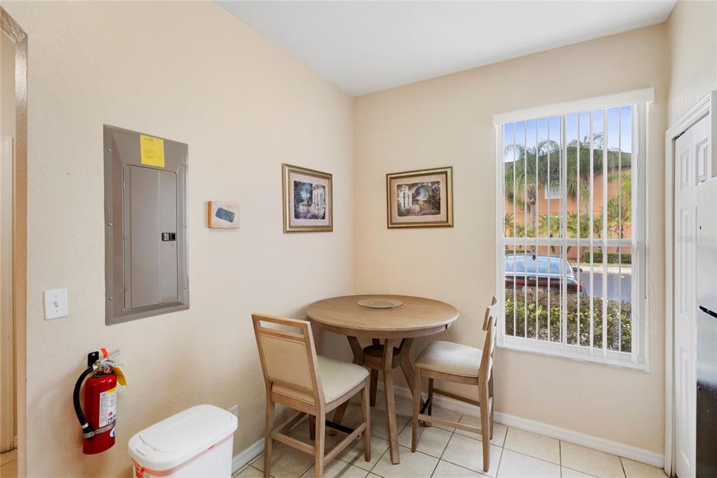 A small kitchen dining area features a black refrigerator, a wall-mounted table, and two chairs — 5702 DELOREAN DRIVE, KISSIMMEE, FL