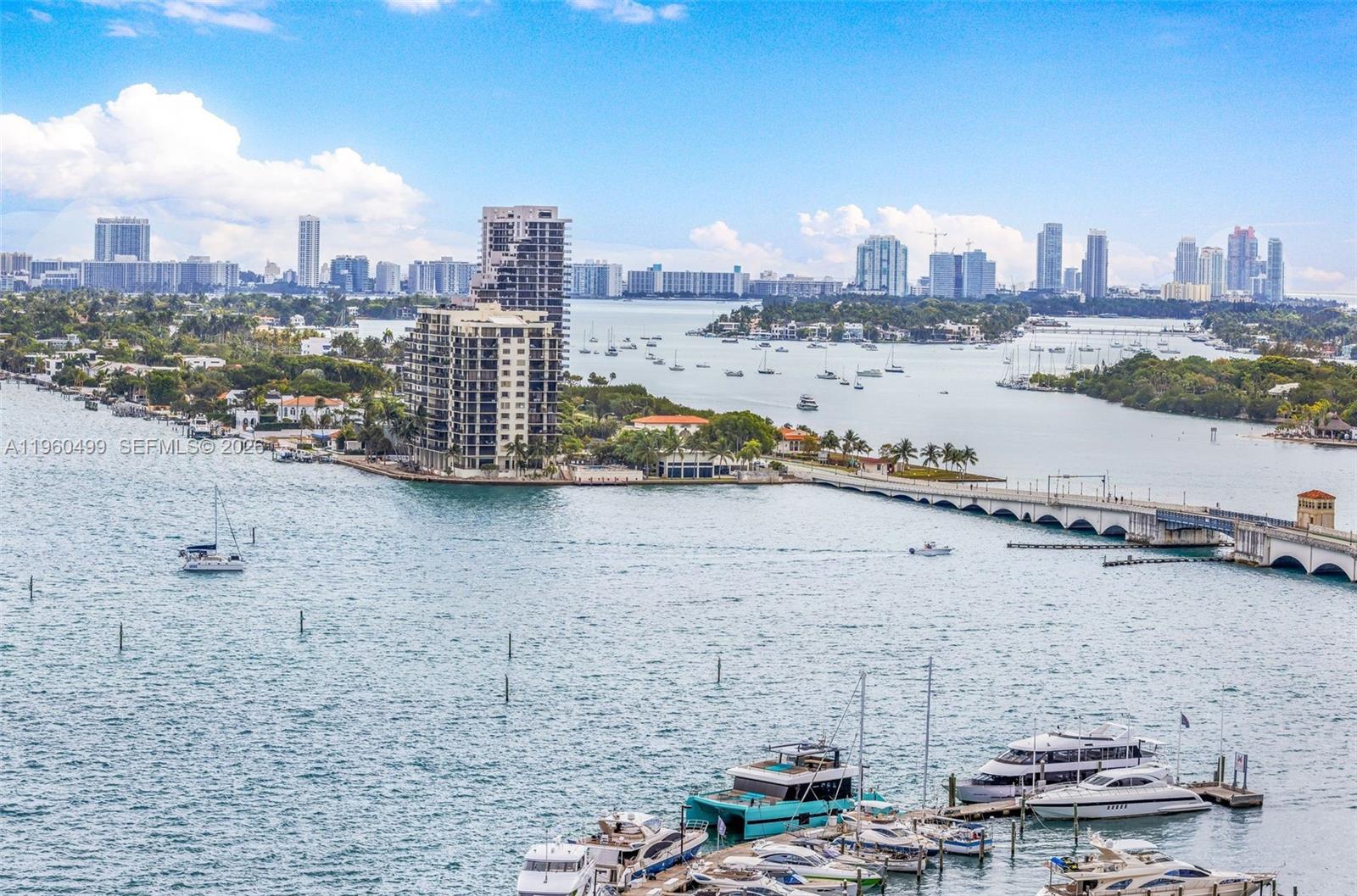 An aerial view shows a marina with yachts, a bridge, and a city skyline — 1750 N Bayshore Dr # 2001, Miami FL 33132, MIAMI, FL