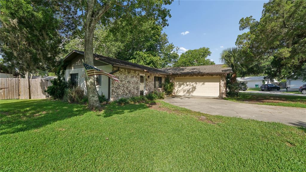 A single-story house with a stone facade, a two-car garage, and a large front lawn — 1968 RED CEDAR CIRCLE, SOUTH DAYTONA, FL
