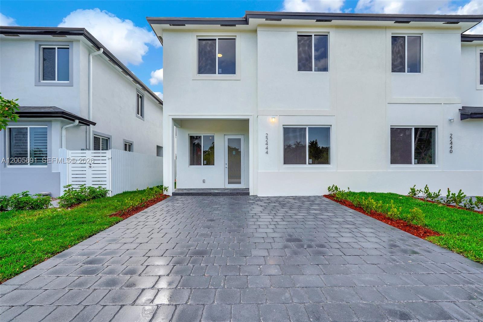 A two-story white townhouse features a gray paver driveway and a recessed front entrance — 22555 SW 125th Ave, Miami FL 33170, MIAMI, FL