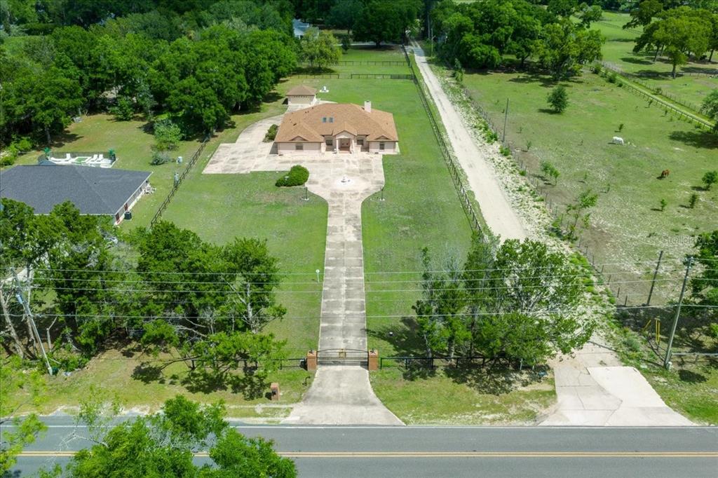 An aerial view shows a house with a long driveway and a gated entrance — 5085 SE 38TH STREET, OCALA, FL