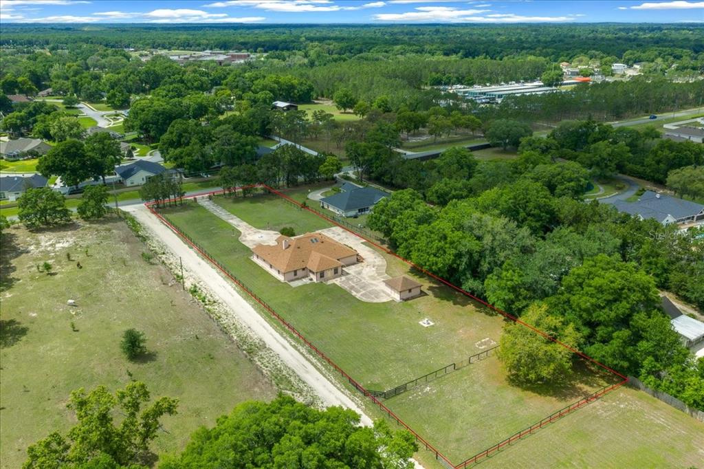 An aerial view shows a single-story house with a large yard enclosed by a fence — 5085 SE 38TH STREET, OCALA, FL