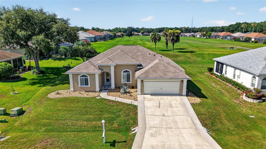 An aerial view of a single-story suburban house with a tan exterior and concrete driveway — 5770 N NW 21ST STREET, OCALA, FL