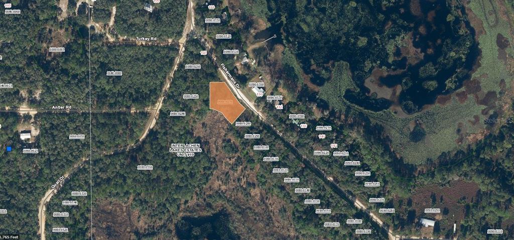 This is an aerial map showing a highlighted vacant lot located along Fishermans Drive — 129 FISHERMANS DRIVE, INTERLACHEN, FL