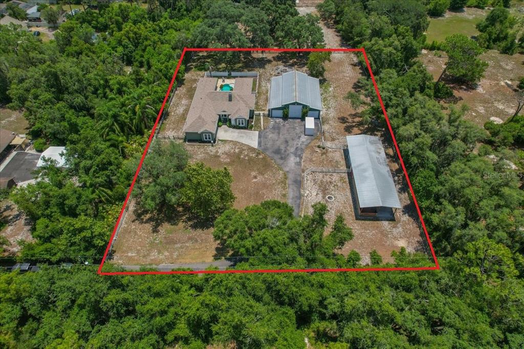 An aerial view shows a house with a pool, a large garage, and a shed — 7014 JONES ROAD, ODESSA, FL