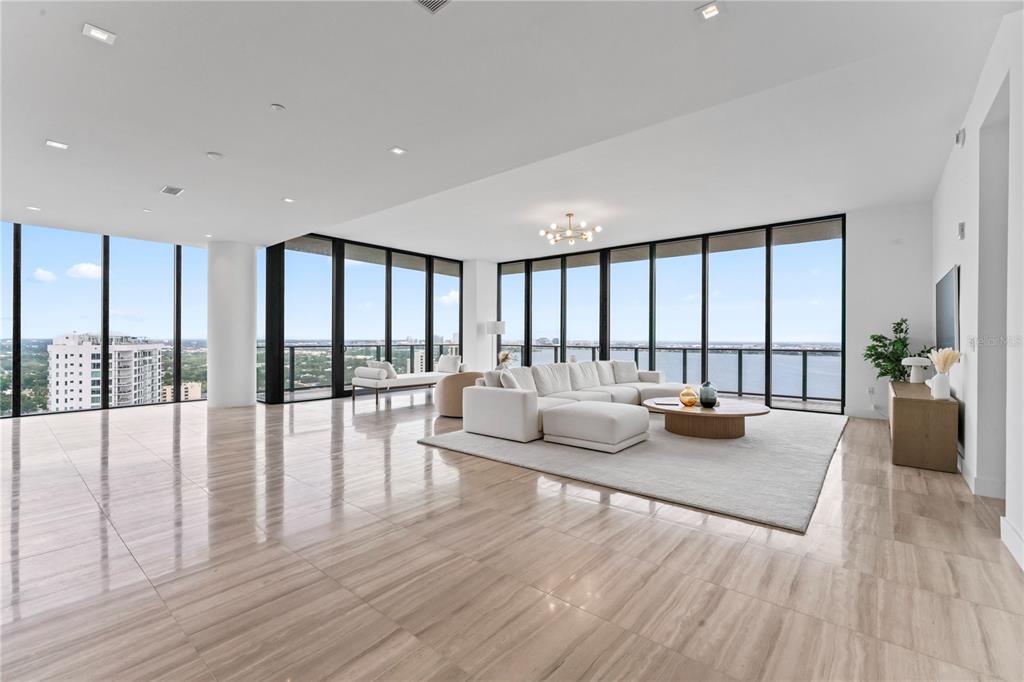 A spacious living room features floor-to-ceiling windows, light tile flooring, and a white sectional sofa — 3101 BAYSHORE BOULEVARD UNIT 2501, TAMPA, FL