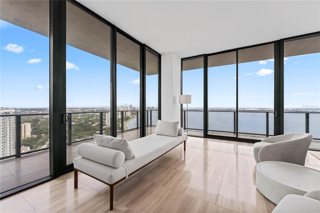 A bright living area features floor-to-ceiling windows, light tile flooring, and a white daybed — 3101 BAYSHORE BOULEVARD UNIT 2501, TAMPA, FL