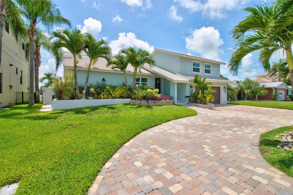 A light blue two-story house with a paver driveway and palm trees in the front yard — 503 JOHNS PASS AVENUE, MADEIRA BEACH, FL