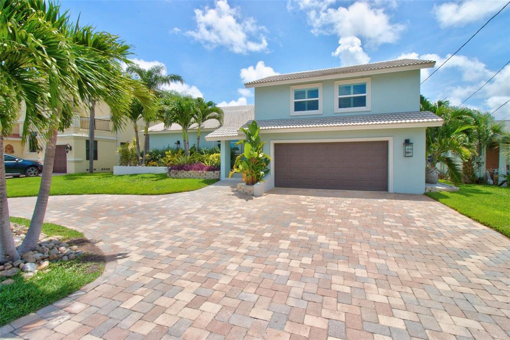 A two-story light blue house with a paved driveway and palm trees in the front — 503 JOHNS PASS AVENUE, MADEIRA BEACH, FL