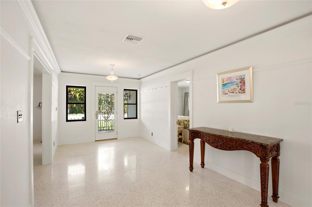 A bright entryway features white walls, terrazzo flooring, a decorative front door, and a console table — 2706 RHODE ISLAND AVENUE, FORT MYERS, FL