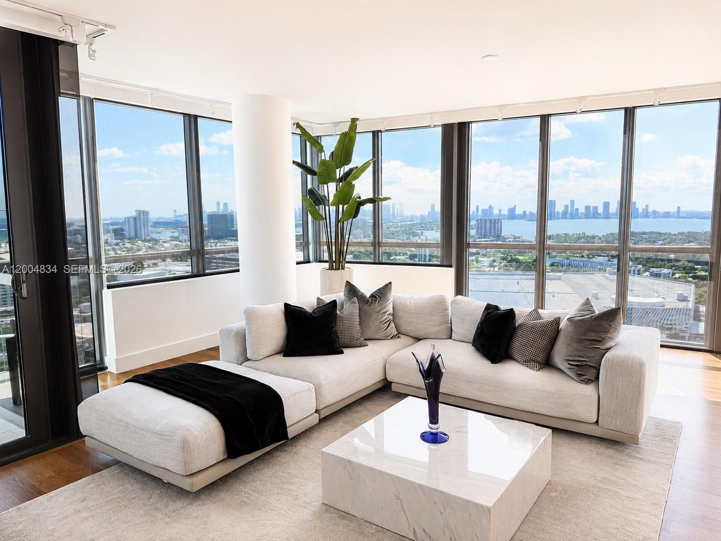 A modern living room features a sectional sofa, marble coffee table, and floor-to-ceiling windows — 101 20th St # 3501, Miami Beach FL 33139, MIAMI BEACH, FL