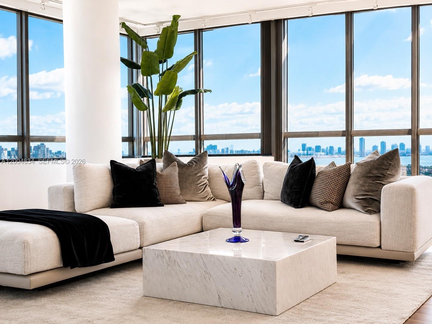 A modern living room features a white sectional sofa, marble coffee table, and floor-to-ceiling windows — 101 20th St # 3501, Miami Beach FL 33139, MIAMI BEACH, FL