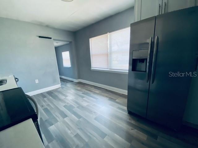 A kitchen features gray walls, light wood-look flooring, and a stainless steel side-by-side refrigerator — 2510 14TH STREET S, ST PETERSBURG, FL