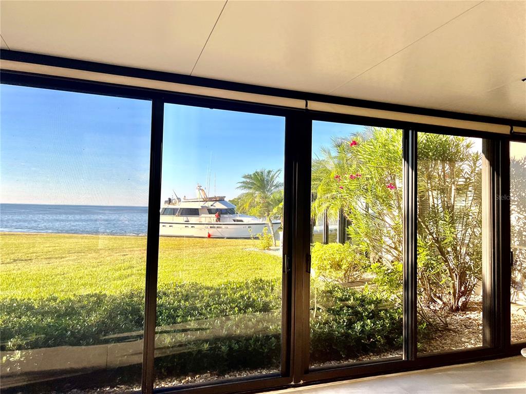 A view of a boat on the water through large sliding glass doors — 3280 SOUTHSHORE DRIVE UNIT 87A, PUNTA GORDA, FL