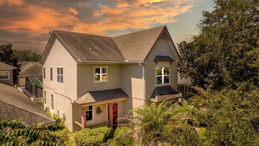 A two-story house with a tan exterior, a shingled roof, and a front porch — 12912 DROXFORD ROAD, WINDERMERE, FL
