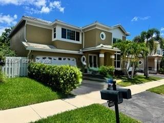 A two-story suburban house with a tan exterior, a garage, and a front lawn — 4441 NW 55th Dr, Coconut Creek FL 33073, COCONUT CREEK, FL