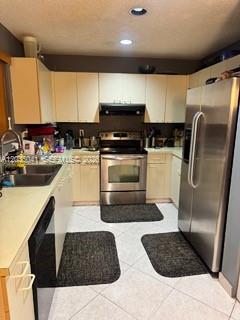 A kitchen features light-colored cabinets, stainless steel appliances, and tiled floors with dark mats — 4441 NW 55th Dr, Coconut Creek FL 33073, COCONUT CREEK, FL