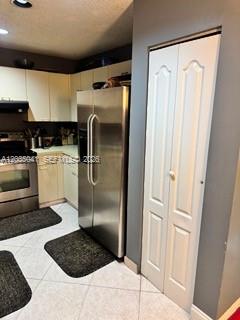 A kitchen features stainless steel appliances, light-colored cabinets, and white tile flooring — 4441 NW 55th Dr, Coconut Creek FL 33073, COCONUT CREEK, FL