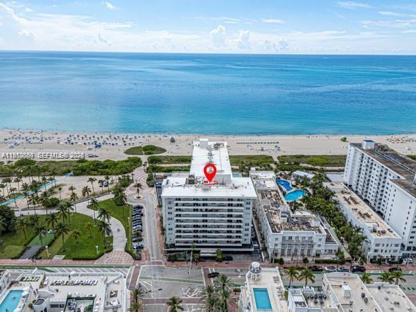 An aerial view shows a multi-story beachfront apartment building with a red location pin — 465 Ocean Dr # 524, Miami Beach FL 33139, MIAMI BEACH, FL