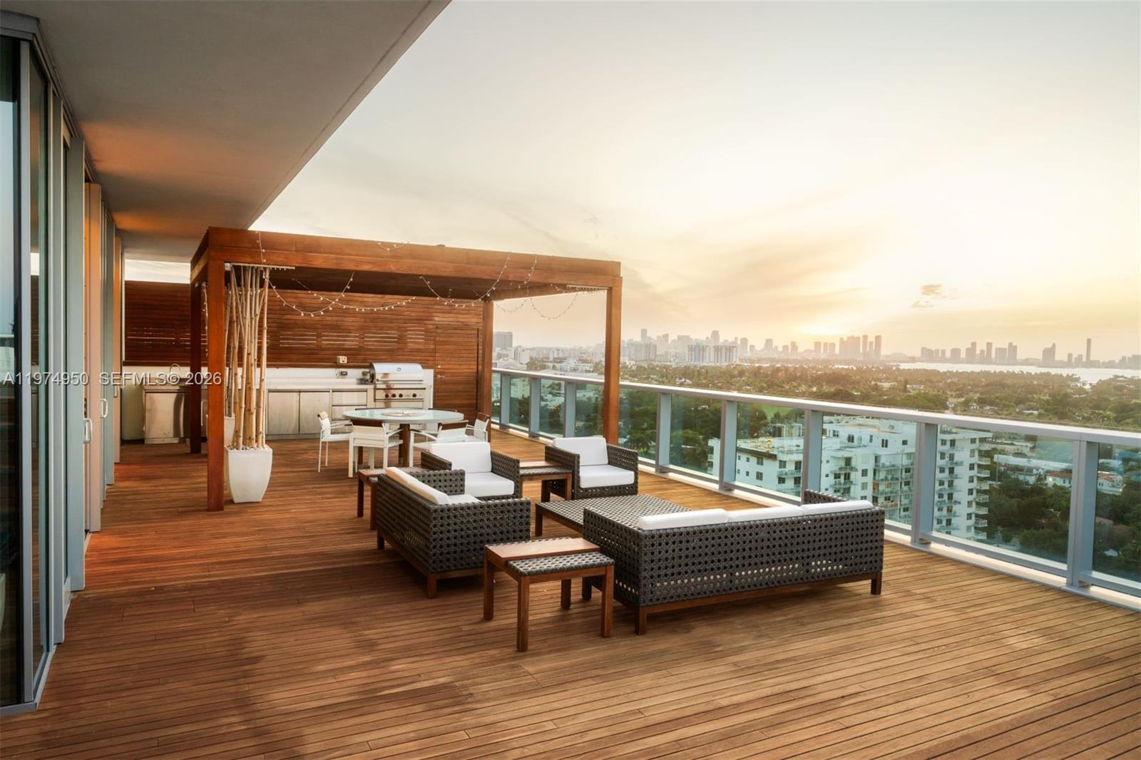 A spacious wooden deck features outdoor seating, a dining area, and a built-in grill — 2901 E Collins Ave # 1602, Miami Beach FL 33140, MIAMI BEACH, FL