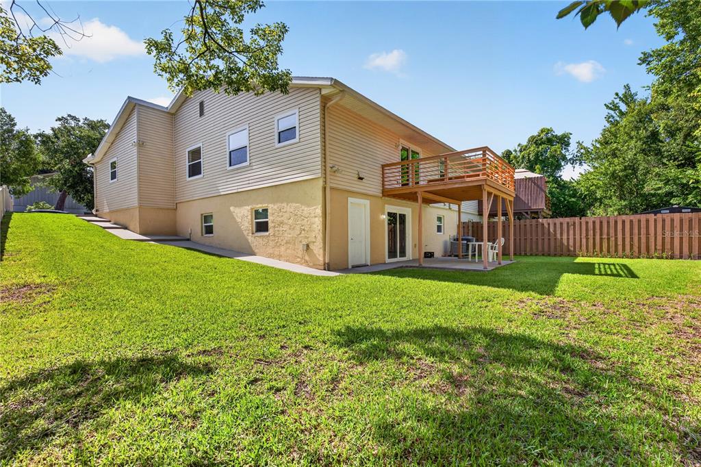 The exterior of a two-story house features a wooden deck, a patio, and a lawn — 51 SANDPIPER CIRCLE, ORMOND BEACH, FL