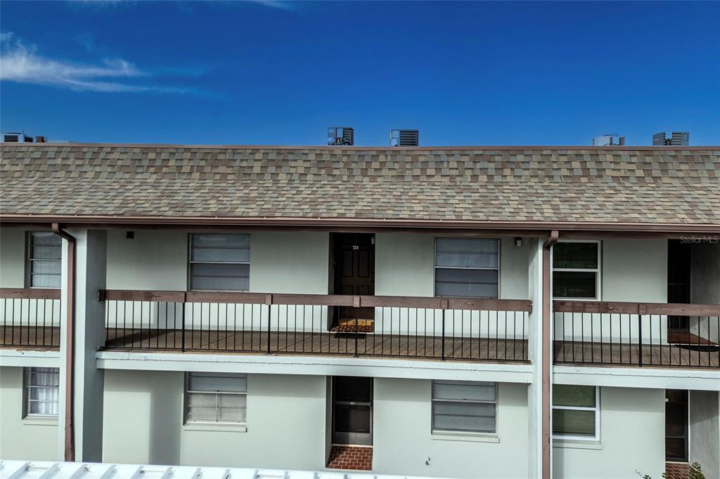 An exterior view of a two-story apartment building with balconies and a shingled roof — 5197 SILENT LOOP UNIT 224, NEW PORT RICHEY, FL