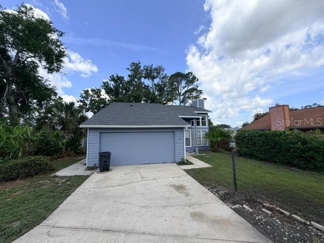A blue house with a two-car garage and a concrete driveway under a cloudy sky — 1194 PELLICIER COURT, PORT ORANGE, FL