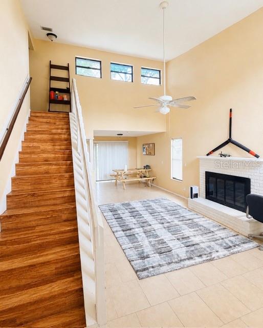 A living room features a fireplace, a staircase, and a high ceiling with a fan — 1194 PELLICIER COURT, PORT ORANGE, FL