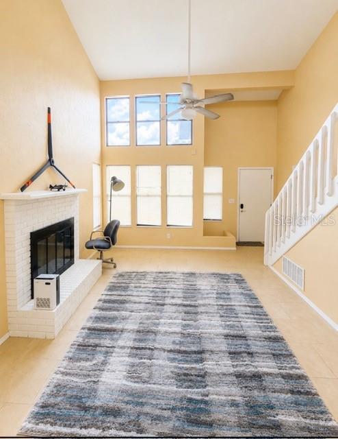 A living room features a white brick fireplace, a large area rug, and a staircase — 1194 PELLICIER COURT, PORT ORANGE, FL
