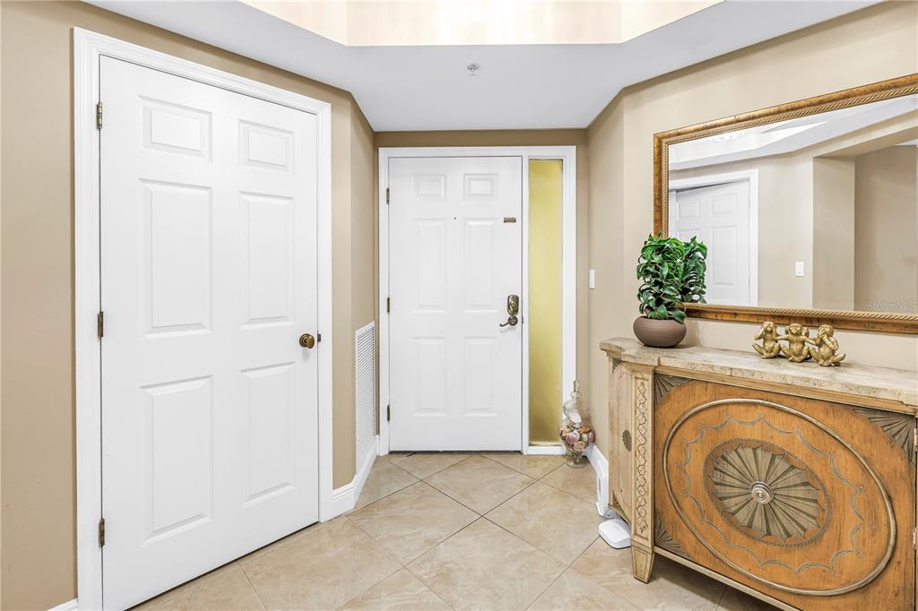 An entryway features beige tile flooring, a white front door, and a decorative wooden console — 16750 GULF BOULEVARD UNIT 313, NORTH REDINGTON BEACH, FL