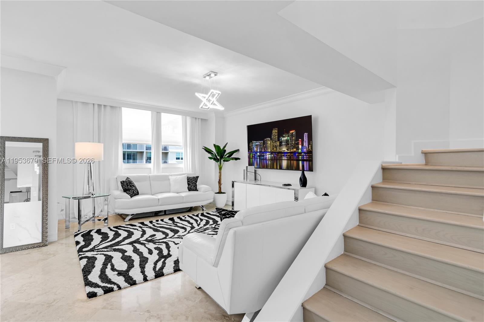 A living room features white sofas, a zebra-print rug, and a staircase with wooden steps — 99 SE Mizner Blvd, Boca Raton FL 33432, BOCA RATON, FL