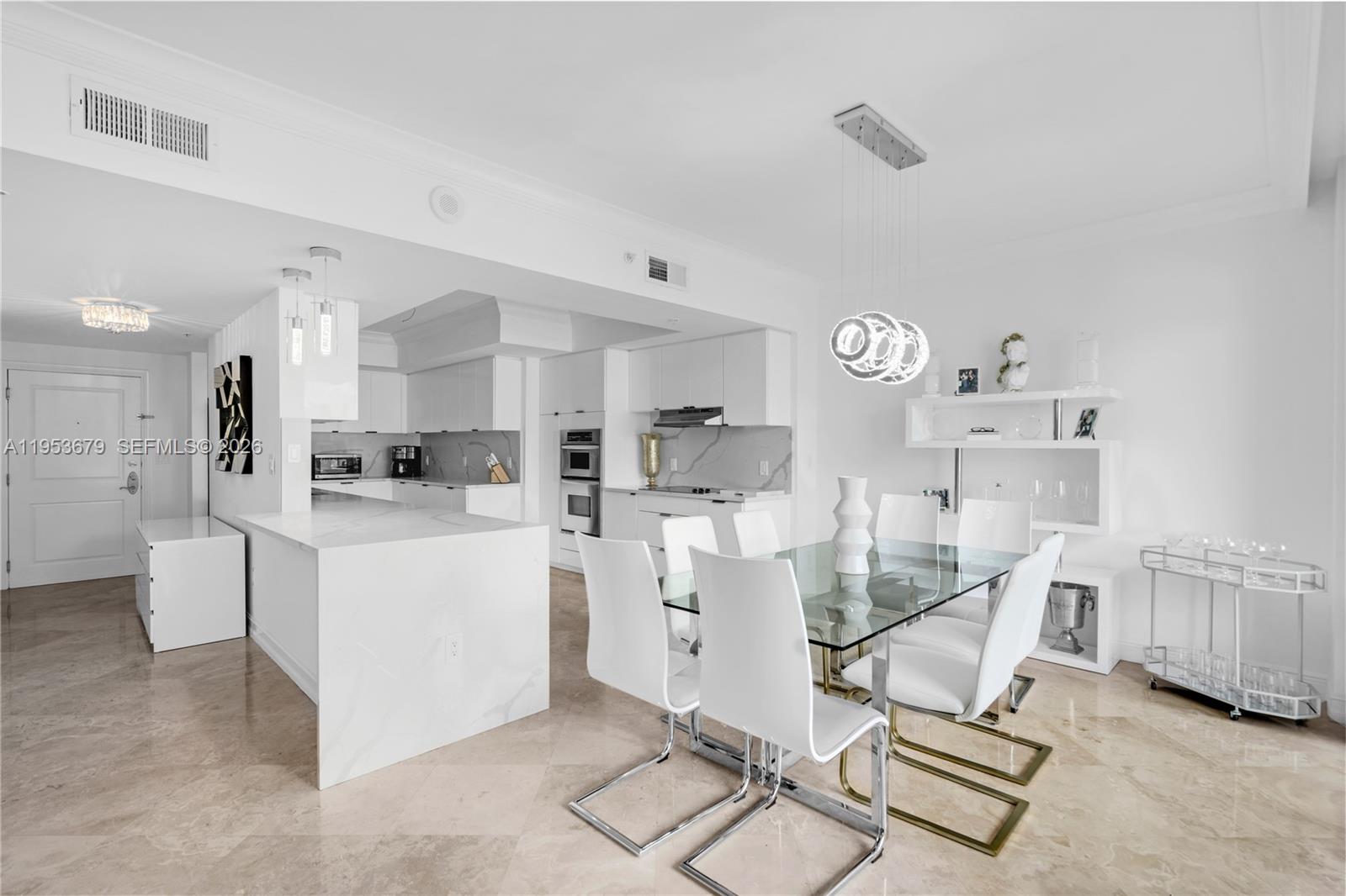 A modern, all-white kitchen and dining area features a glass table and marble flooring — 99 SE Mizner Blvd, Boca Raton FL 33432, BOCA RATON, FL