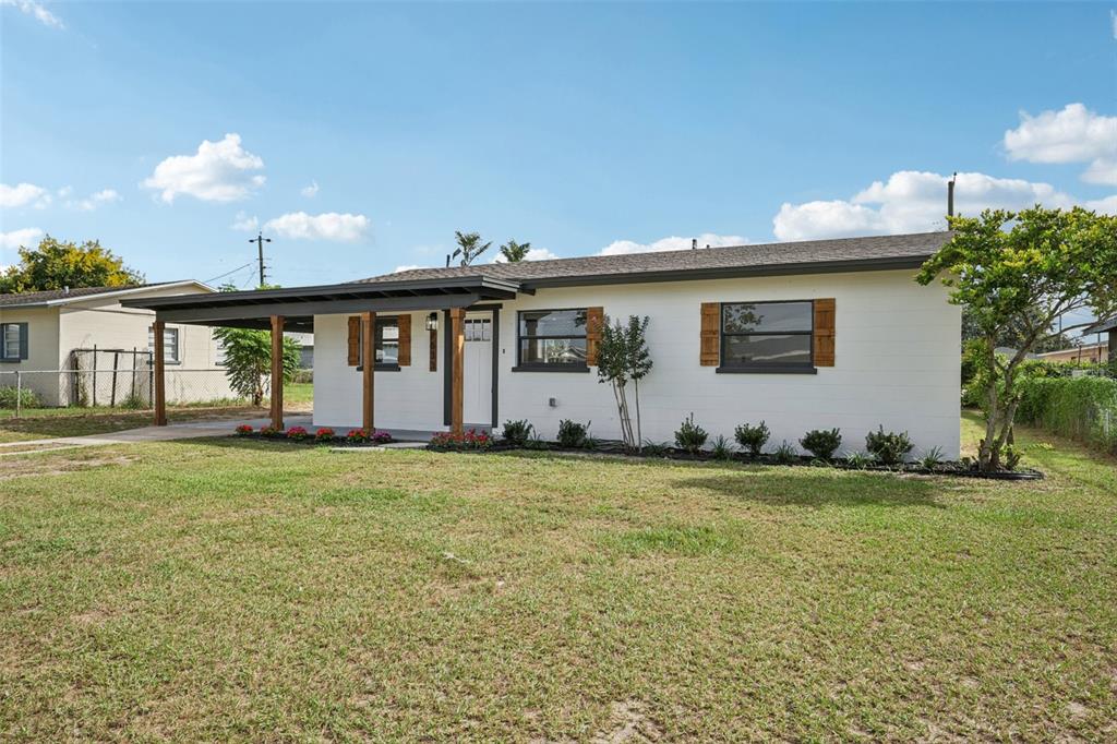 A white single-story house with a covered front porch and wooden support posts — 2633 ROYAL DRIVE, LAKELAND, FL