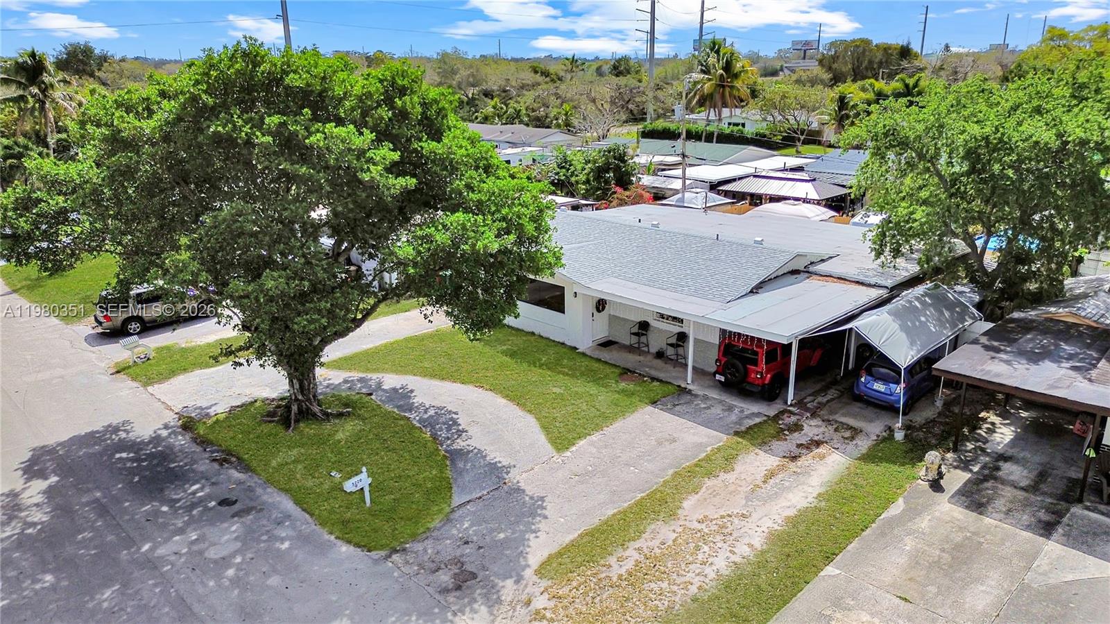 An aerial view shows a single-story house with a driveway, carport, and large front tree — 5220 SW 57th St, Davie FL 33314, DAVIE, FL