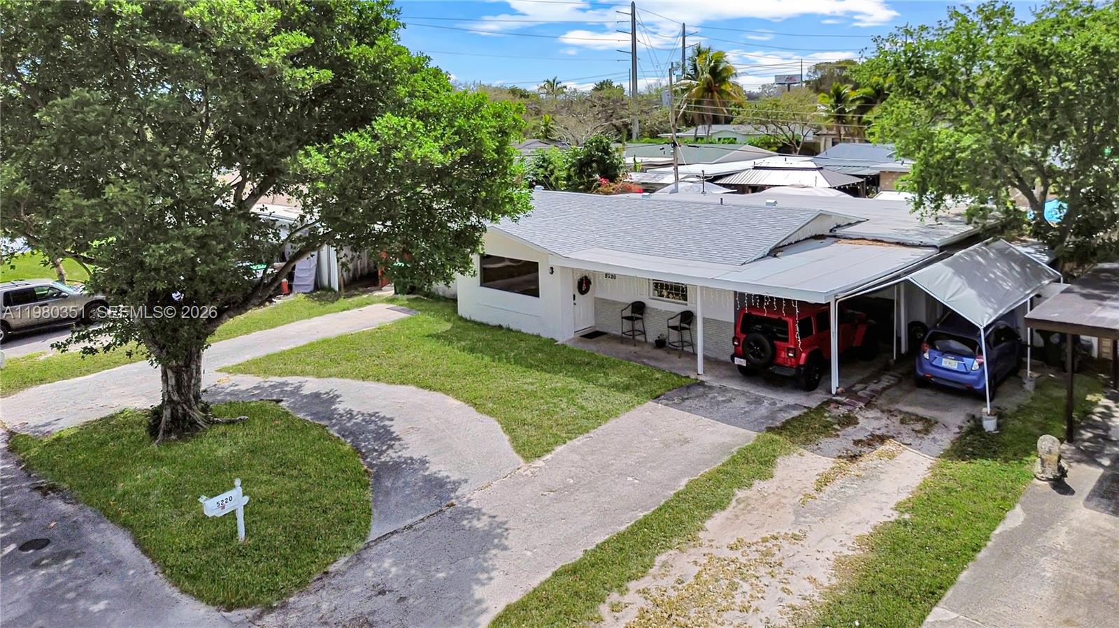 An aerial view shows a single-story house with a driveway, carport, and large front tree — 5220 SW 57th St, Davie FL 33314, DAVIE, FL