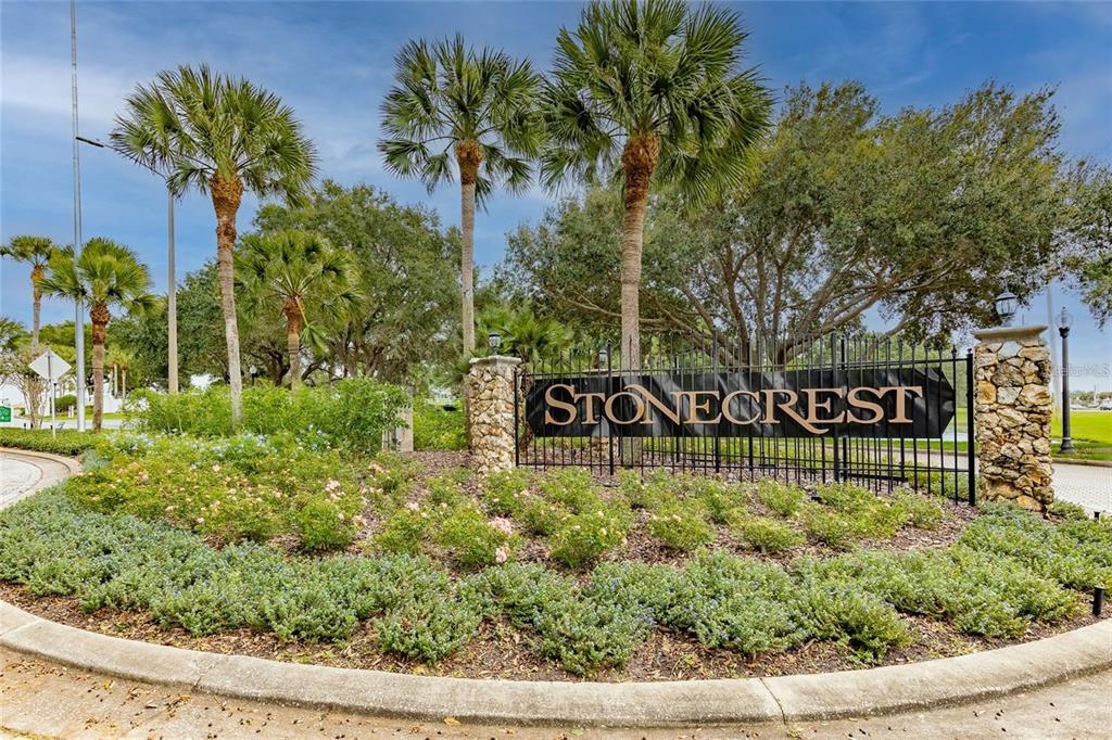 A stone sign reading Stonecrest stands behind a landscaped garden with palm trees and fencing — 17585 SE 122ND TERRACE, SUMMERFIELD, FL