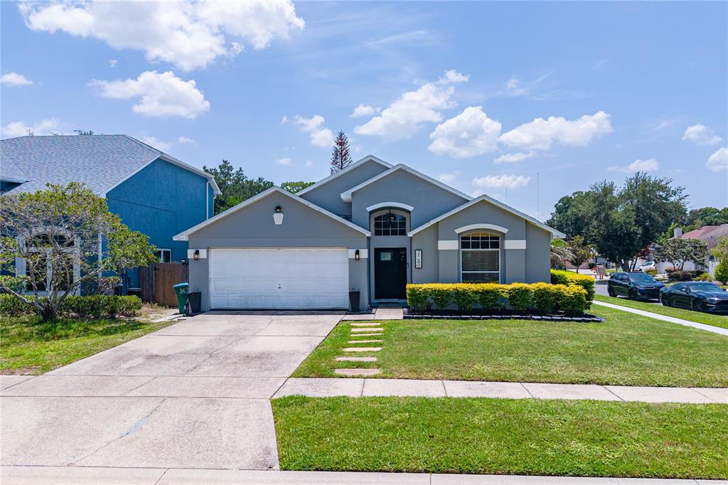 A single-story house with a gray exterior, a two-car garage, and a front lawn — 2180 TORTOISE SHELL DRIVE, MAITLAND, FL