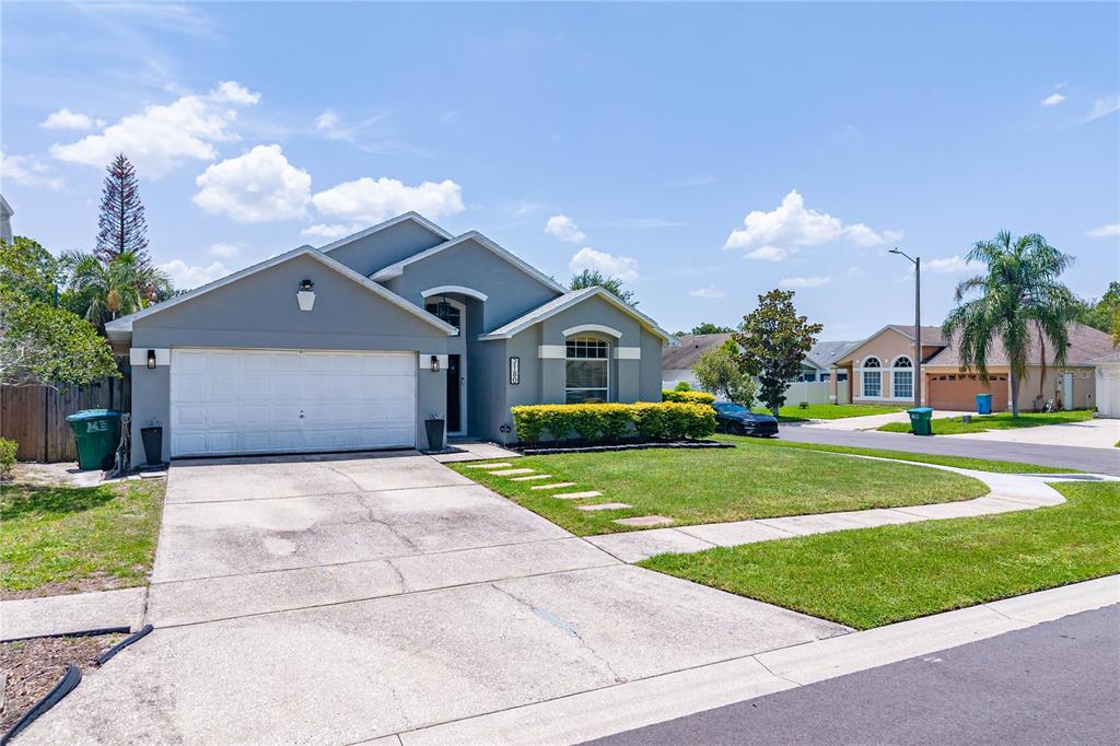A single-story house with a gray exterior, a two-car garage, and a concrete driveway — 2180 TORTOISE SHELL DRIVE, MAITLAND, FL
