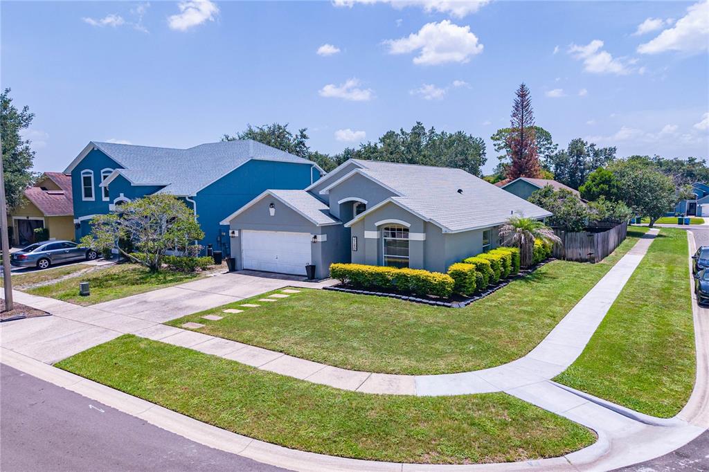 A single-story house with a white garage and a landscaped front yard on a corner — 2180 TORTOISE SHELL DRIVE, MAITLAND, FL