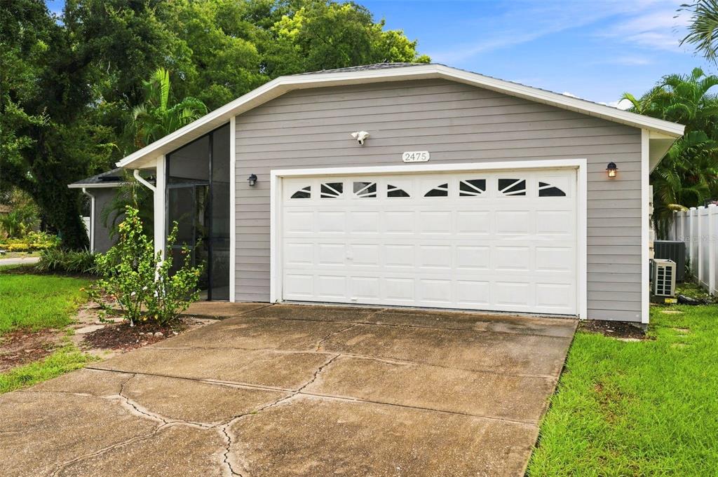 A gray detached garage with a white door and a screened-in side entrance — 2475 GULFBREEZE CIRCLE, PALM HARBOR, FL