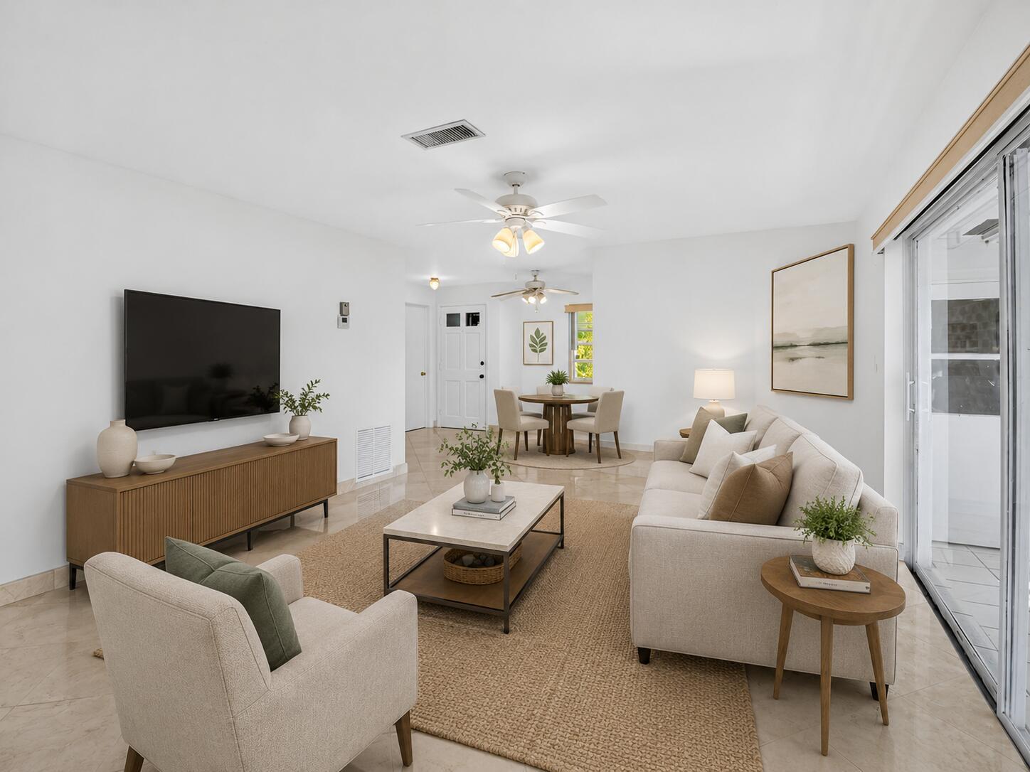 A bright living room features a beige sofa, armchair, coffee table, and a dining area — 300 NW 42nd Street, Boca Raton FL 33431, BOCA RATON, FL