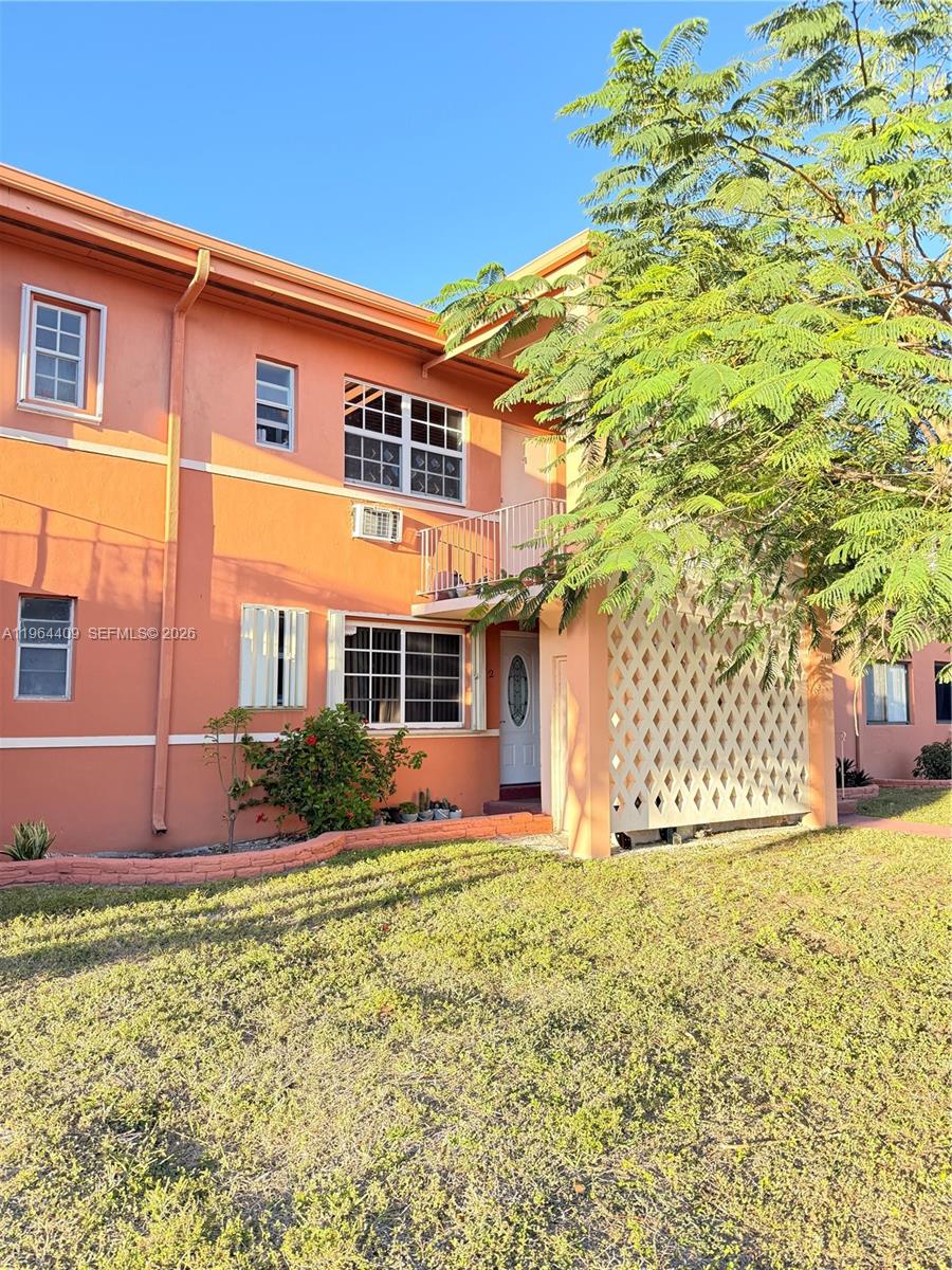 A two-story peach-colored apartment building features a small balcony and a white lattice screen — 3411 SW 11th St # 3B, Miami FL 33135, MIAMI, FL