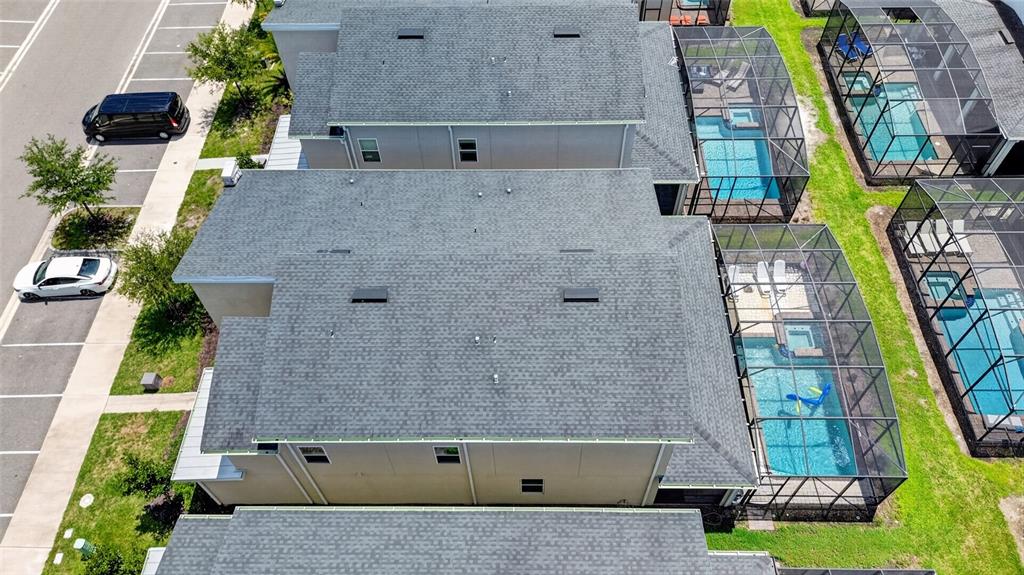 An aerial view shows several townhomes with screened-in swimming pools and adjacent parking spaces — 4536 TARGET BOULEVARD, KISSIMMEE, FL