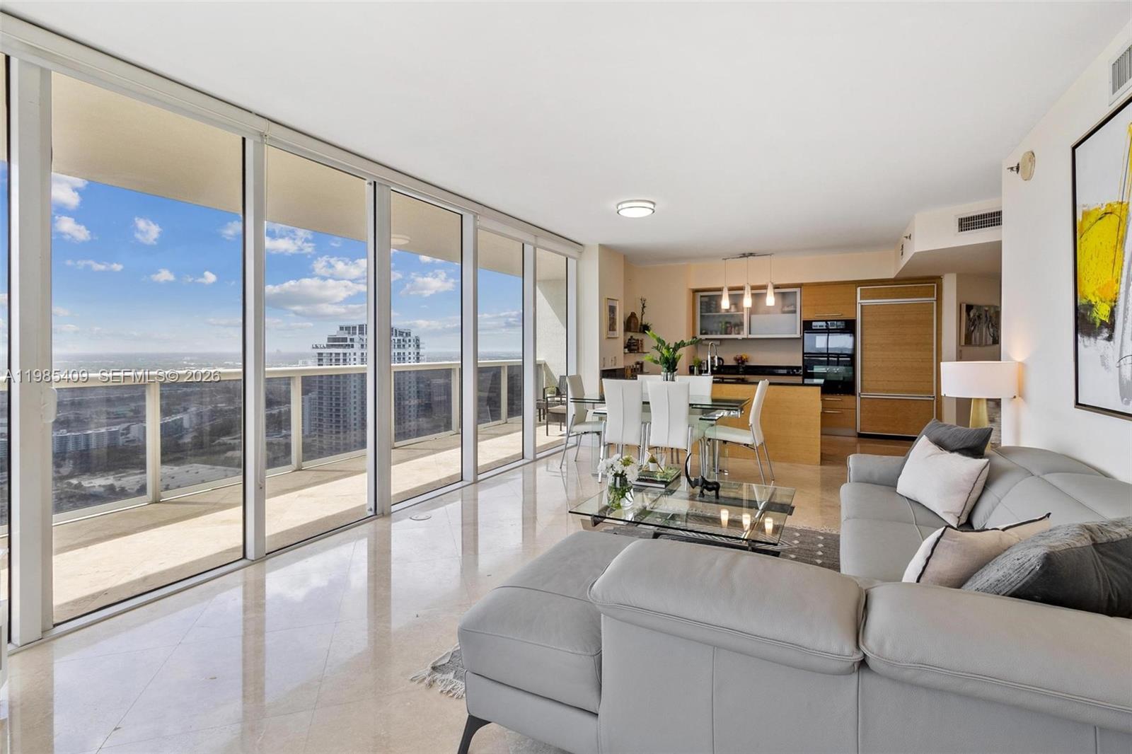 A modern living and dining area with floor-to-ceiling windows overlooking a city skyline — 1830 S Ocean Dr # 4706, Hallandale Beach FL 33009, HALLANDALE BEACH, FL