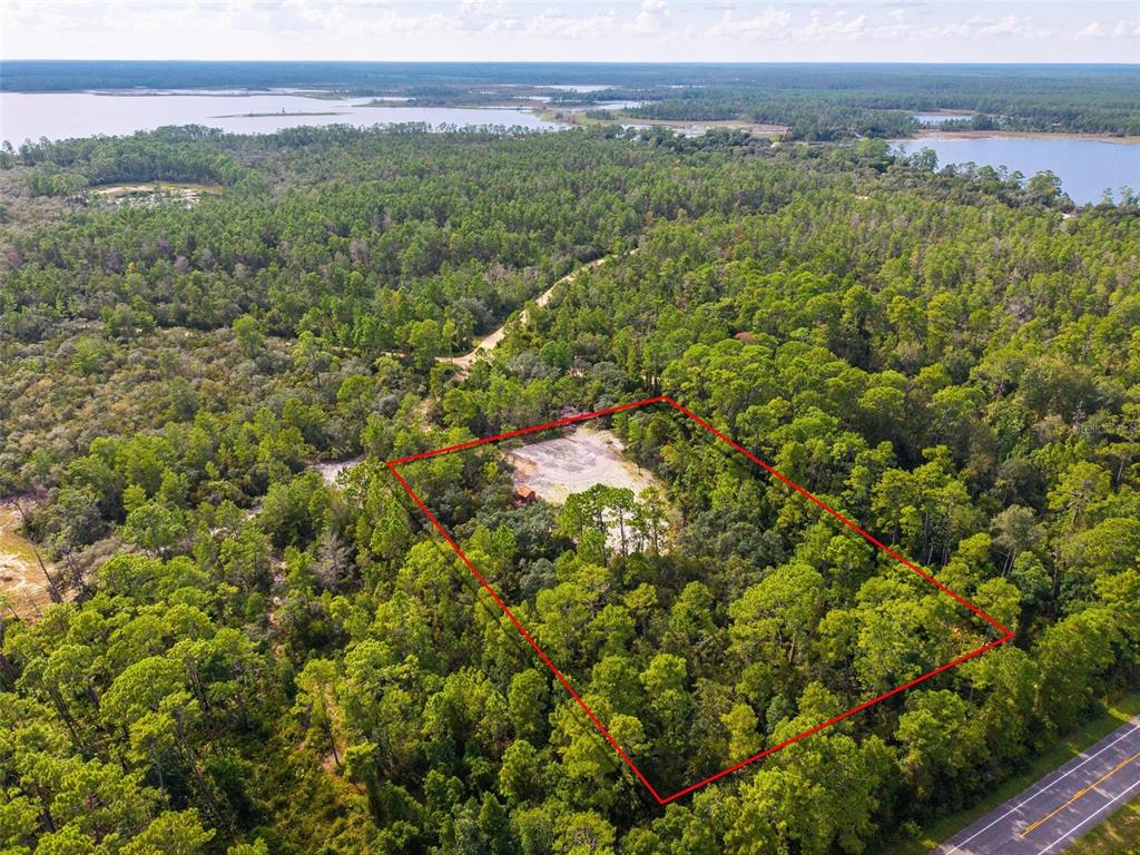 An aerial view shows a rectangular plot of wooded land with a cleared area — 52215 STATE ROAD 19, ALTOONA, FL