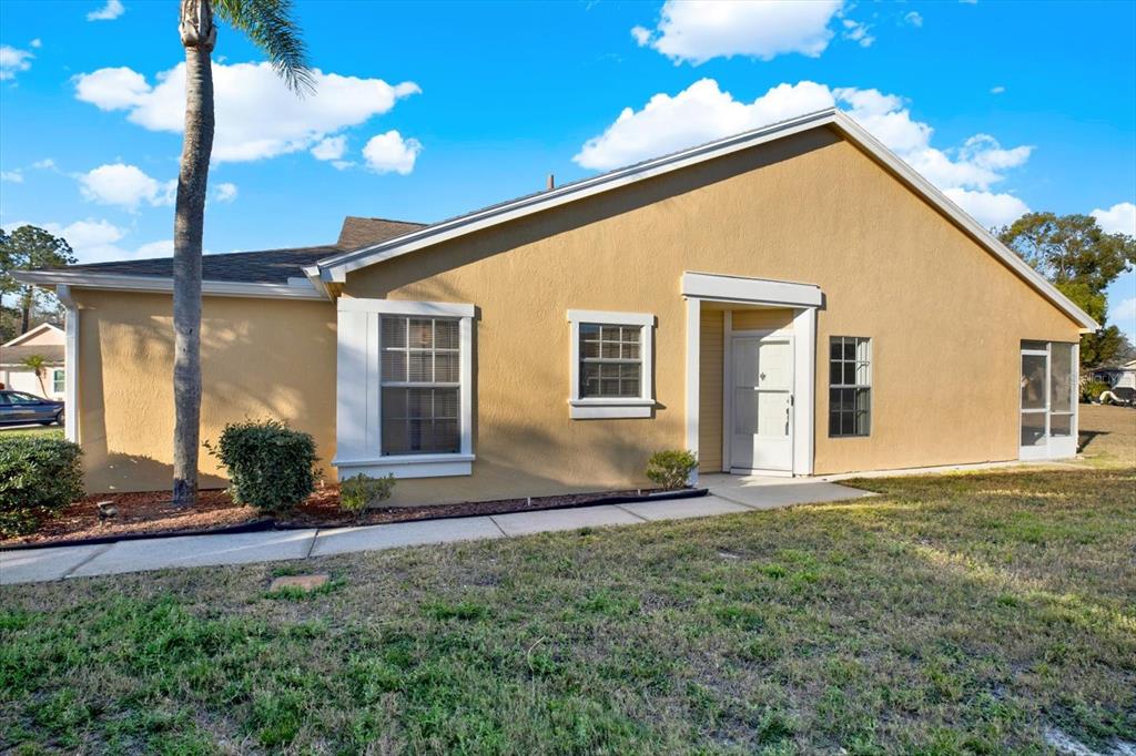 A tan, single-story house with a white front door and a palm tree in front — 4208 BOSTON CIRCLE, NEW PORT RICHEY, FL