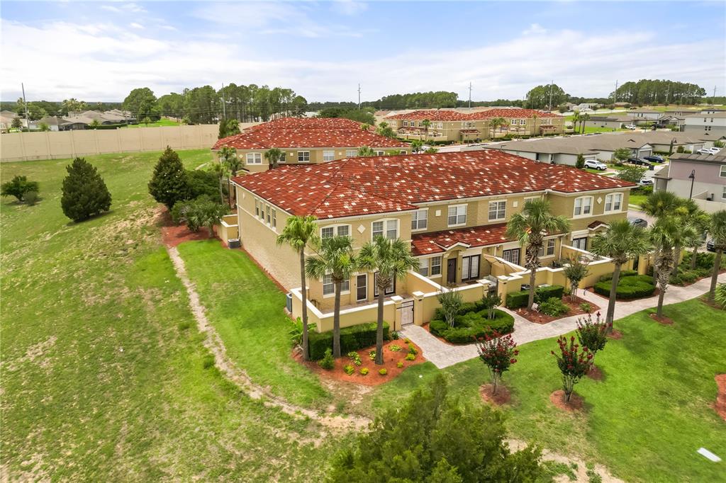 An aerial view of a multi-unit residential building with a red tile roof and landscaping — 2828 BELLA VISTA DRIVE, DAVENPORT, FL