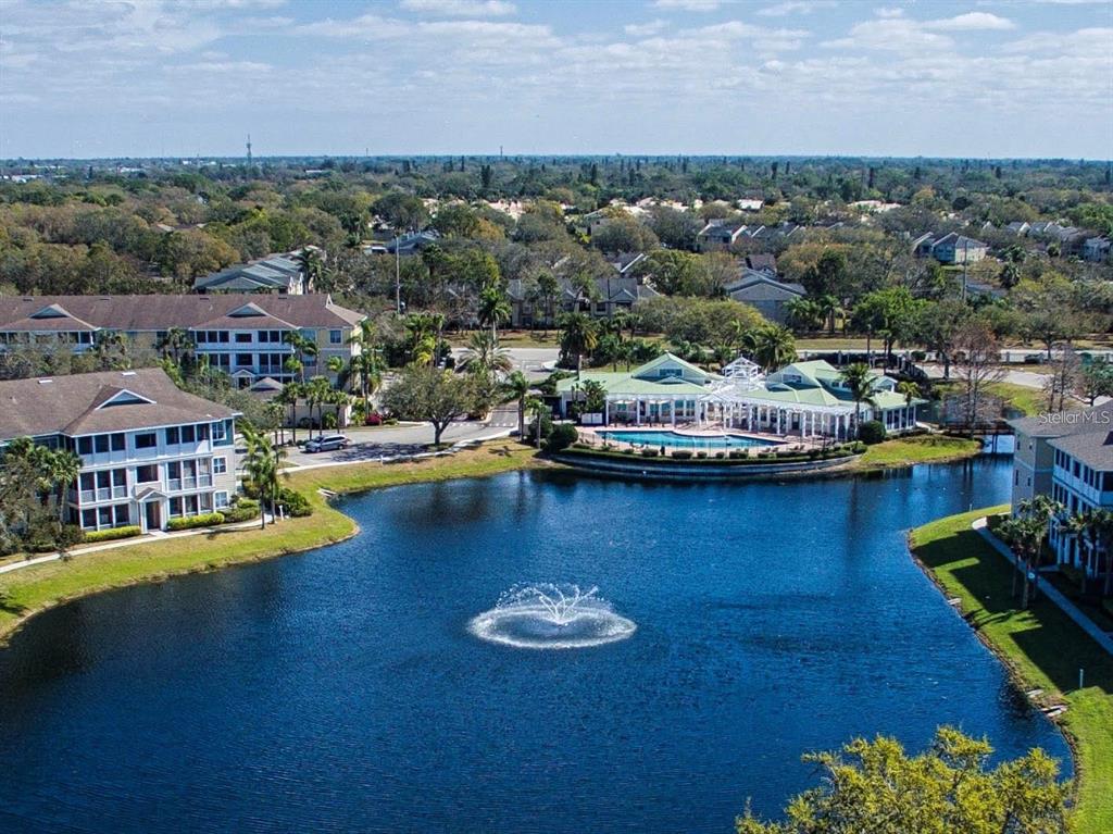 An aerial view shows a lake with a fountain surrounded by apartment buildings and amenities — 4802 51ST STREET W UNIT 1421, BRADENTON, FL
